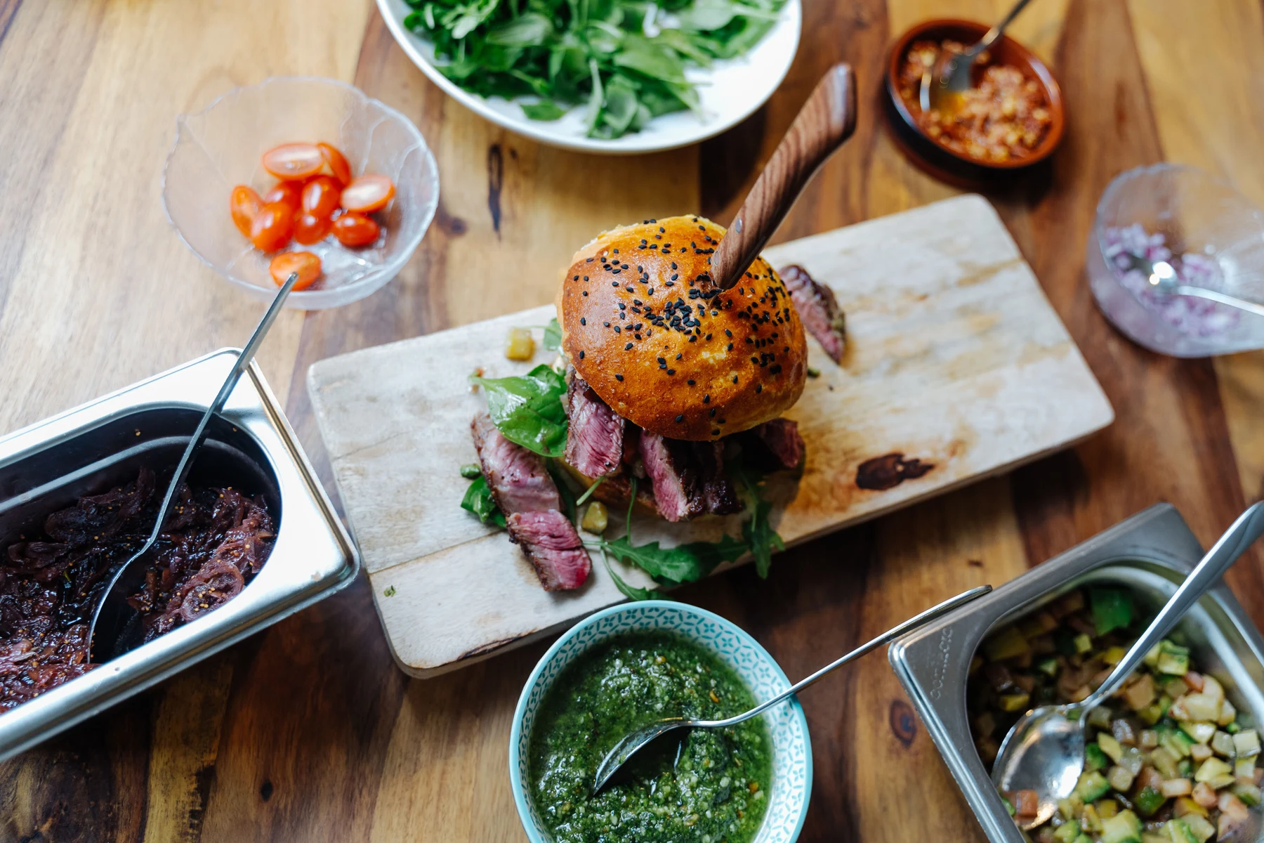 Burger mit bunten Beilagen in einer lebendigen Tischszene